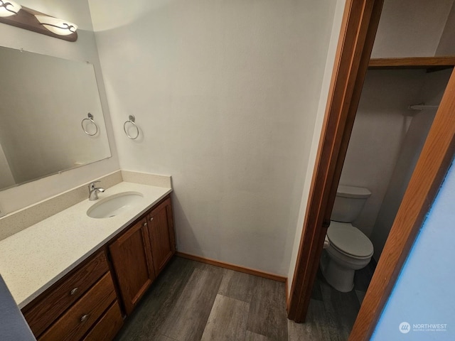 bathroom with hardwood / wood-style floors, vanity, and toilet