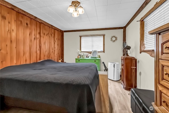 bedroom featuring crown molding and light hardwood / wood-style flooring