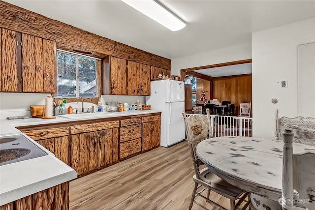 kitchen featuring sink, light hardwood / wood-style flooring, and white fridge