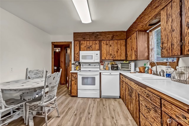 kitchen with white appliances, light hardwood / wood-style flooring, and sink