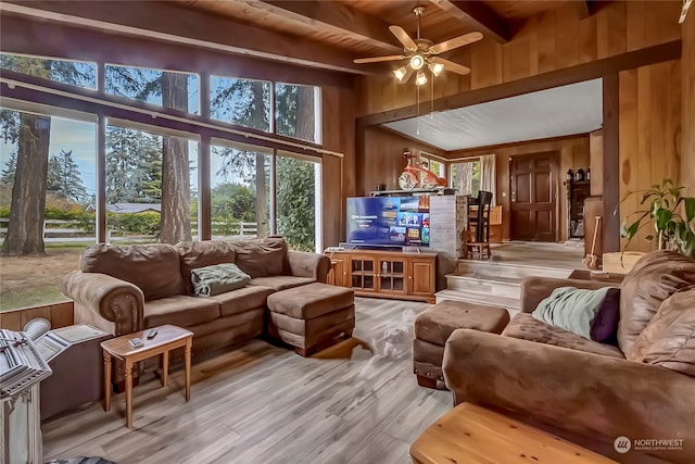 living room with light hardwood / wood-style flooring, wood walls, beam ceiling, and ceiling fan