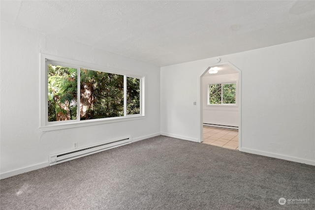 carpeted spare room featuring a baseboard heating unit and a textured ceiling