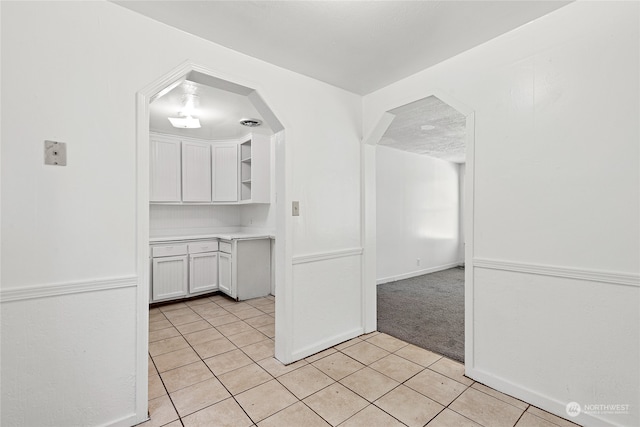 kitchen with light tile patterned floors and white cabinets