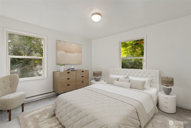 carpeted bedroom featuring multiple windows and baseboard heating