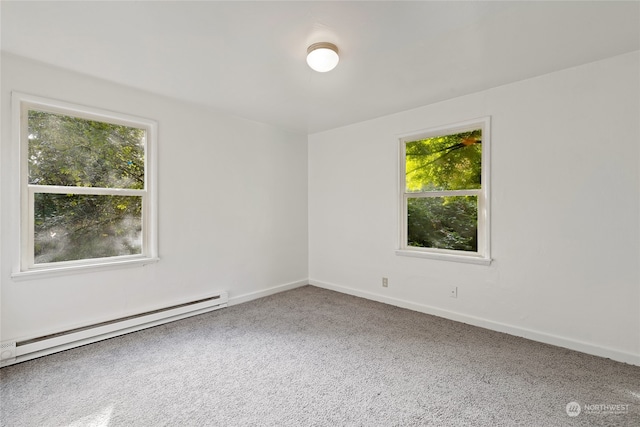 empty room with a baseboard radiator, carpet flooring, and plenty of natural light