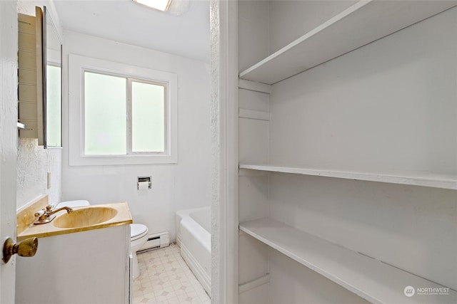 bathroom featuring vanity, toilet, a tub to relax in, and a baseboard heating unit