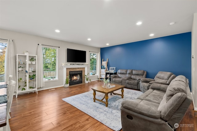 living room with dark wood-type flooring and a tile fireplace