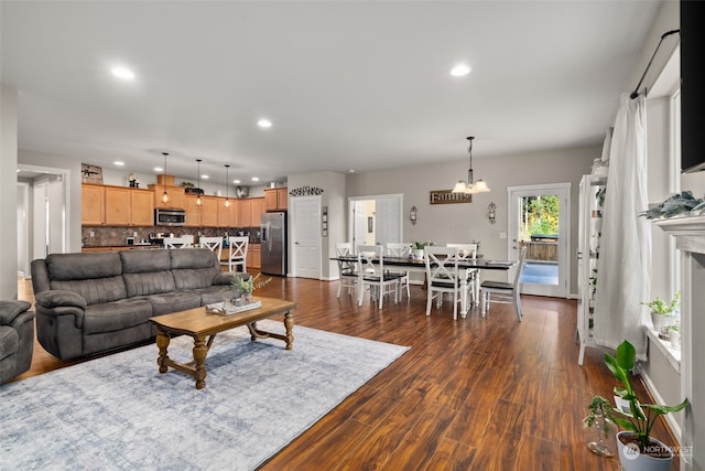 living room with dark wood-type flooring and a chandelier