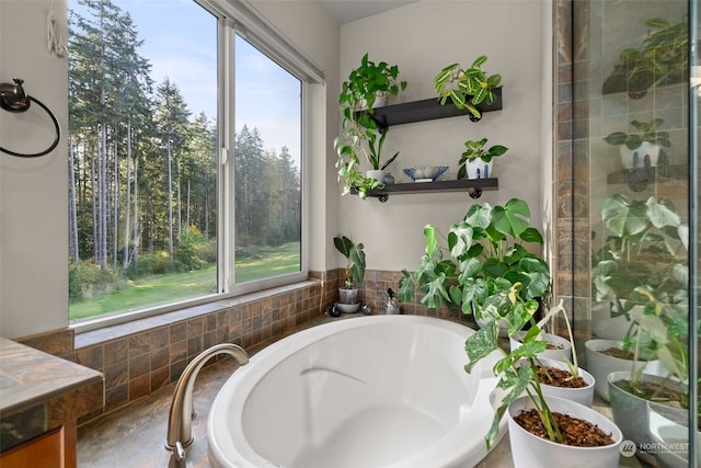 bathroom with tiled tub and a wealth of natural light