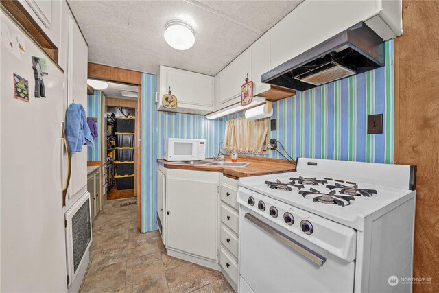 137 Mountain View Dr N, Ashford, WA 98304 - kitchen with white cabinetry, white appliances, range hood, and wallpapered walls
