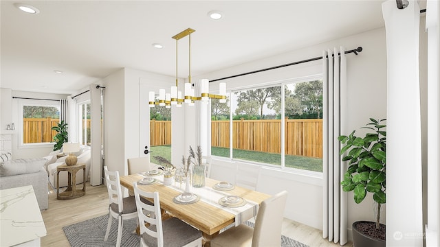 dining area with light hardwood / wood-style floors and a chandelier