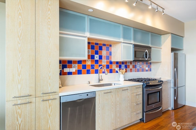 kitchen with tasteful backsplash, appliances with stainless steel finishes, sink, and dark hardwood / wood-style floors