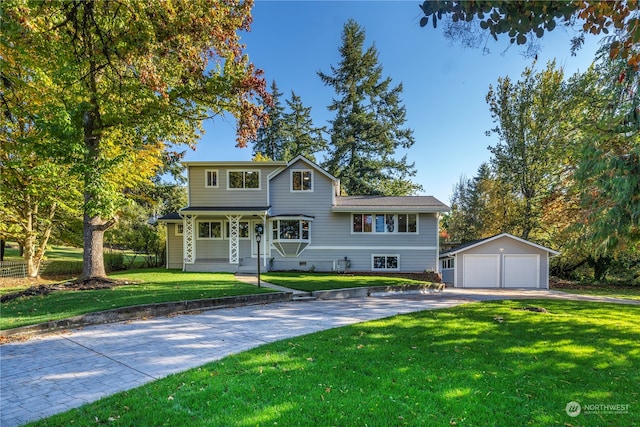 view of front of home featuring a front yard, an outbuilding, and a garage