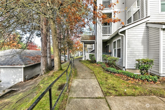 view of side of home featuring a balcony and a yard