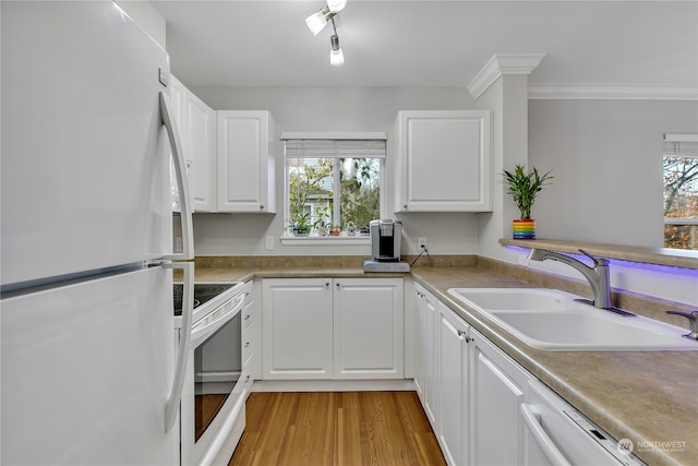 kitchen with a healthy amount of sunlight, sink, white cabinets, and white appliances