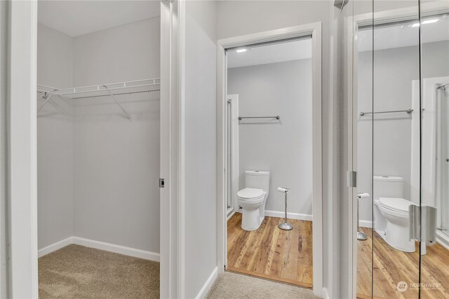 bathroom with toilet and hardwood / wood-style flooring