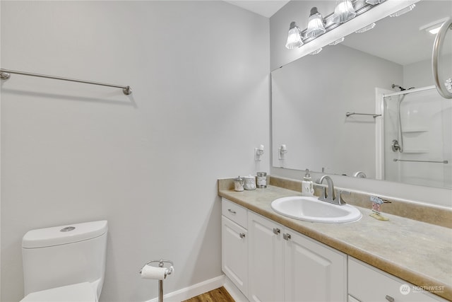 bathroom featuring a shower with door, hardwood / wood-style flooring, toilet, and vanity