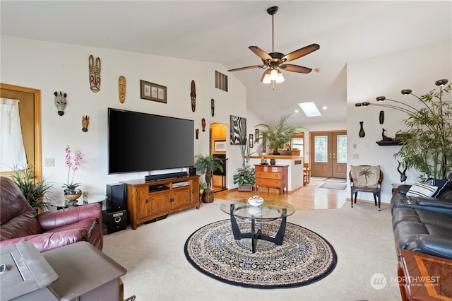 living room featuring french doors, lofted ceiling with skylight, light hardwood / wood-style flooring, and ceiling fan