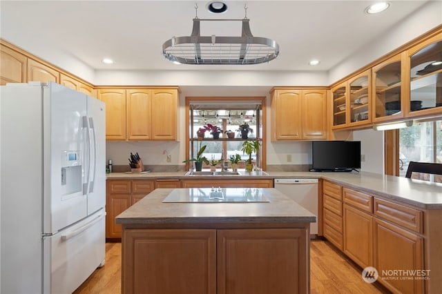 kitchen with white appliances, light hardwood / wood-style flooring, kitchen peninsula, and a kitchen island