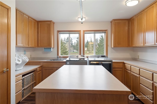 kitchen with sink, washer and dryer, and a center island