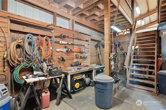 interior space featuring wood walls, a workshop area, and concrete flooring