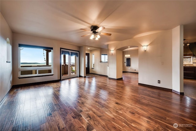 212 Grandview Ave, Camano Island, WA 98282 - unfurnished living room featuring arched walkways, baseboards, a ceiling fan, and wood finished floors