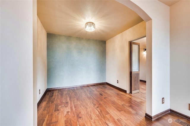 212 Grandview Ave, Camano Island, WA 98282 - unfurnished room with wood finished floors, baseboards, and arched walkways