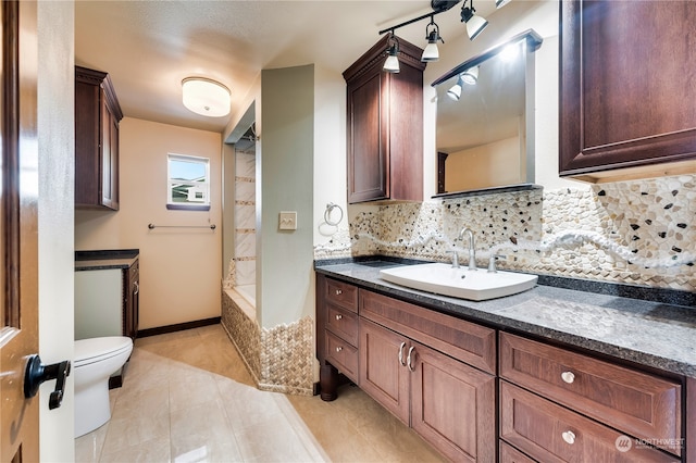 bathroom with vanity, tasteful backsplash, toilet, and tile patterned floors