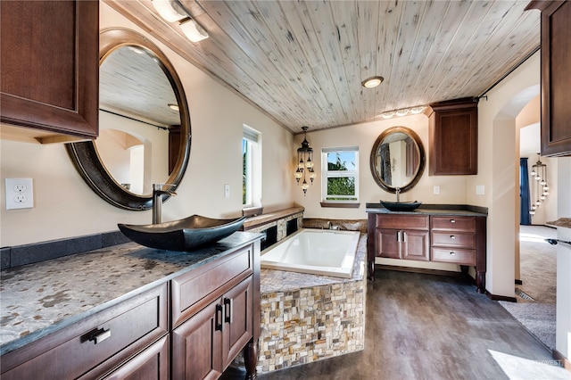 bathroom with vanity, hardwood / wood-style flooring, wooden ceiling, and tiled tub