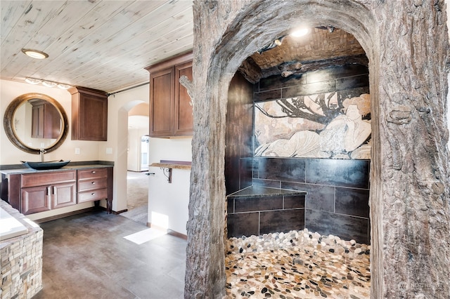 bathroom with vanity, wood ceiling, ornamental molding, and concrete floors