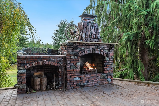 view of patio / terrace featuring an outdoor brick fireplace