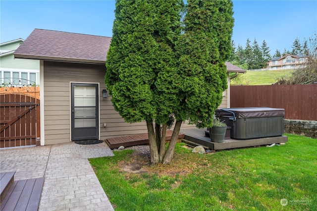 exterior space featuring a hot tub, a wooden deck, and a yard