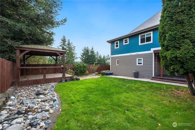 rear view of property featuring a gazebo, a yard, and a patio