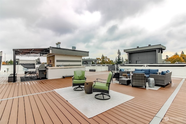 wooden terrace with area for grilling and an outdoor hangout area