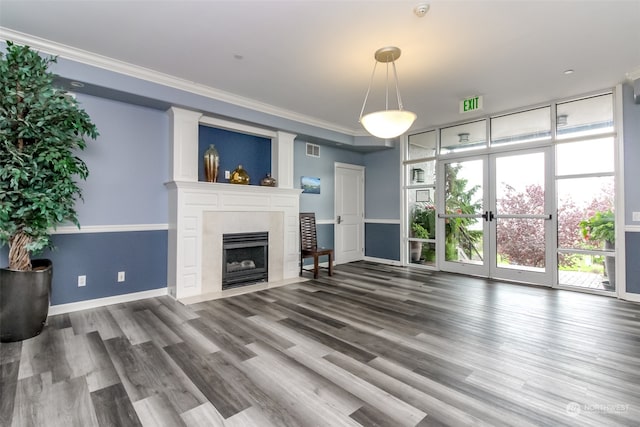 unfurnished living room with a tiled fireplace, crown molding, and hardwood / wood-style floors