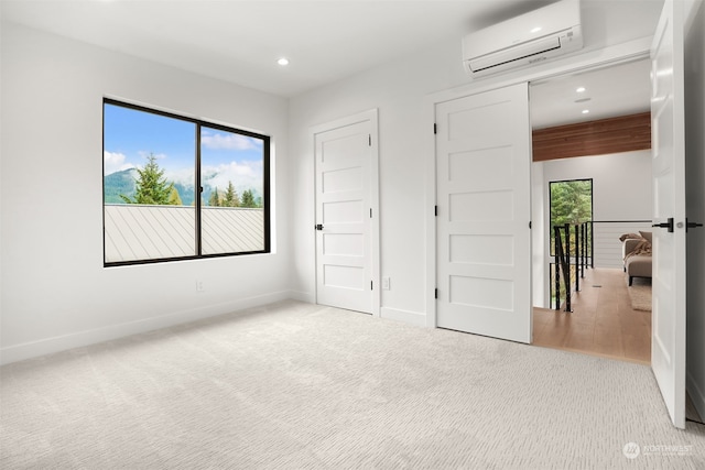 unfurnished bedroom featuring an AC wall unit and light colored carpet