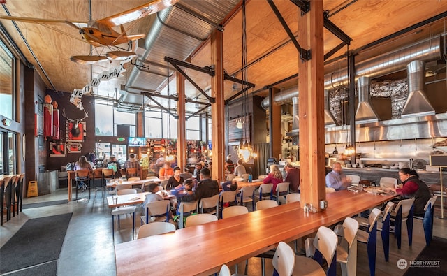 unfurnished dining area featuring concrete flooring, high vaulted ceiling, and wooden ceiling