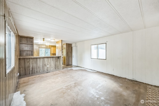 unfurnished living room featuring a textured ceiling and a healthy amount of sunlight