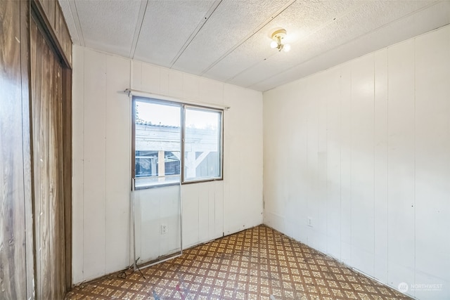 unfurnished room with a textured ceiling