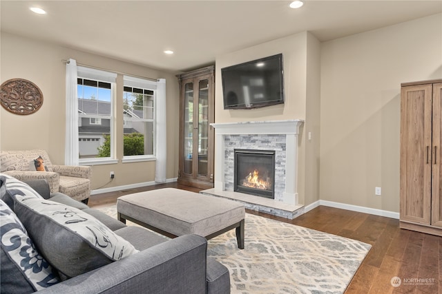 living room with dark wood-type flooring and a fireplace