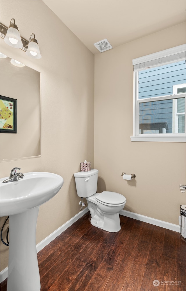 bathroom with toilet, wood-type flooring, and sink