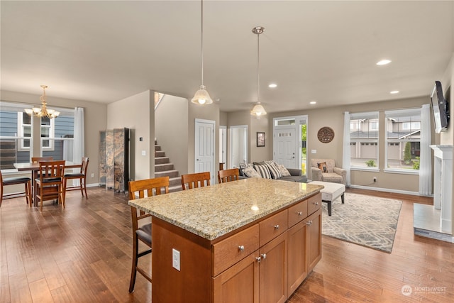 kitchen featuring a kitchen bar, wood-type flooring, pendant lighting, and a kitchen island