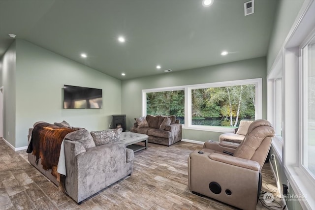 living room featuring lofted ceiling, hardwood / wood-style floors, and a healthy amount of sunlight