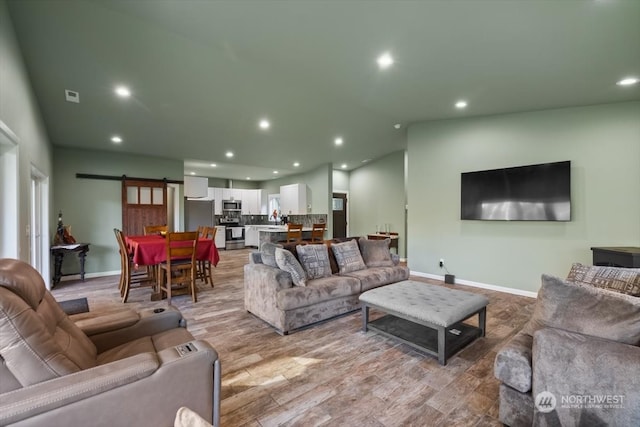 living room with light hardwood / wood-style flooring and a barn door