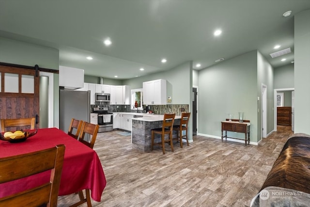 dining room featuring light hardwood / wood-style floors and a barn door