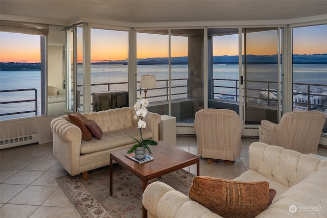 tiled living room with a water view and a baseboard radiator