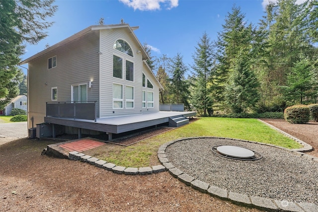 back of house with a deck and a lawn