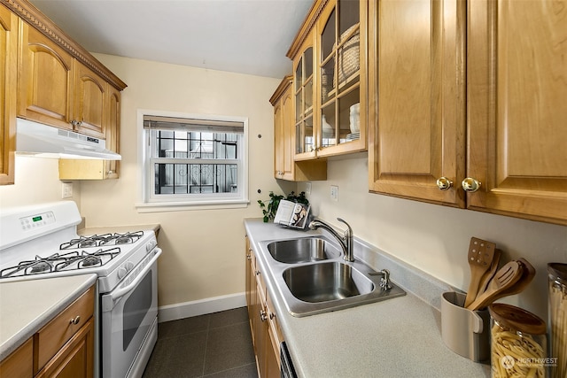 kitchen featuring sink, white gas range, and dark tile patterned flooring