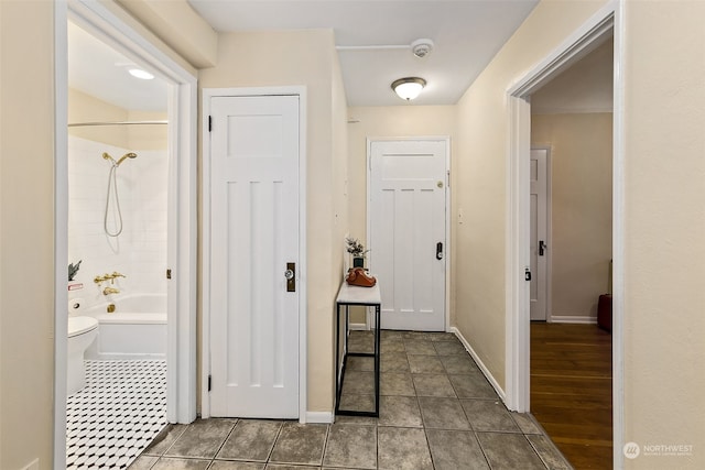 hallway featuring dark tile patterned floors