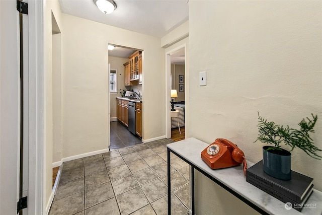 corridor featuring sink and light tile patterned flooring